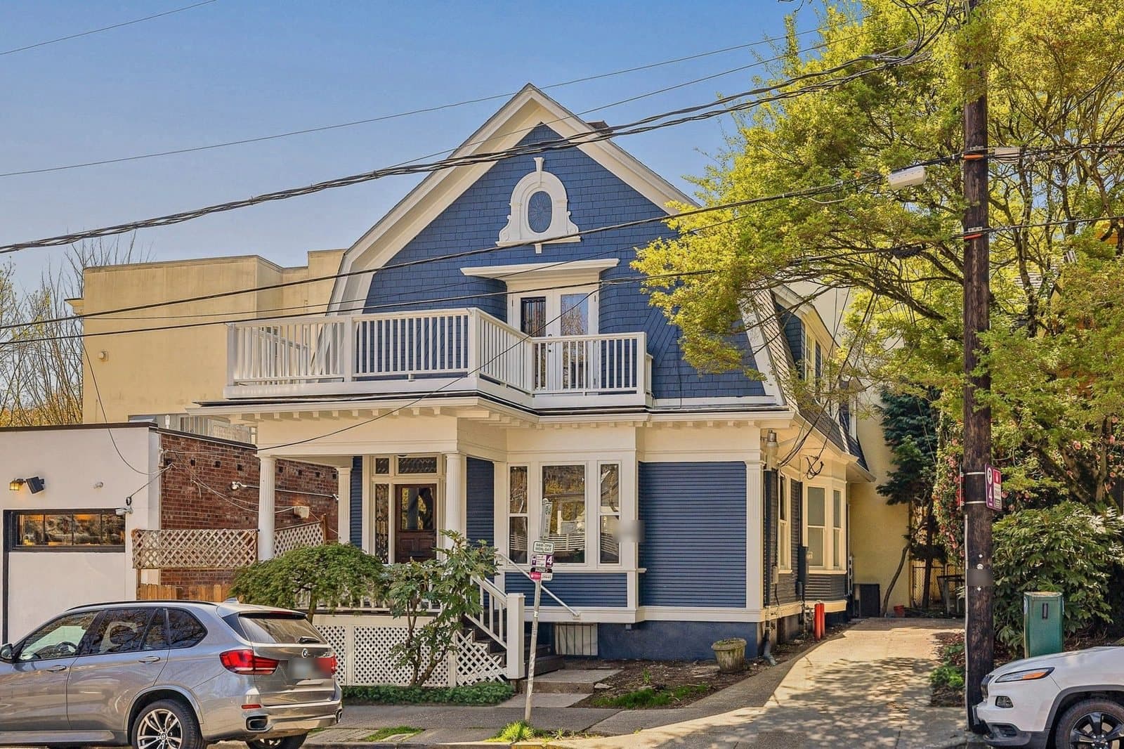 Listing photo: a blue Victorian with a white balcony in Northwest Portland